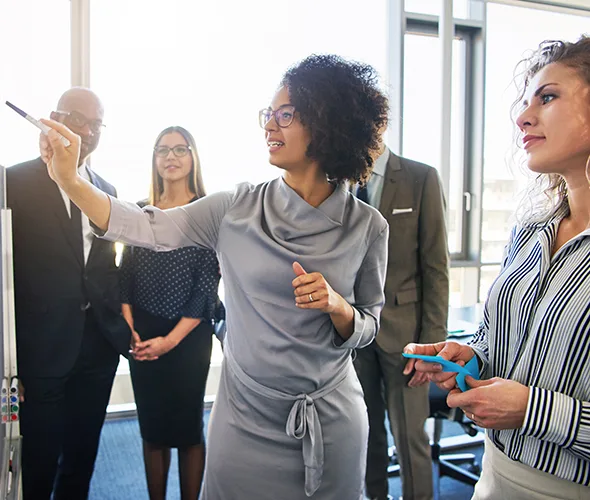 Diverse,Group,Of,Focused,Businesspeople,Brainstorming,Together,On,A,Whiteboard